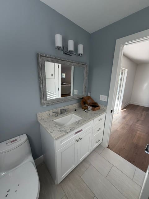 Guest bathroom with quartz countertop and framed mirror