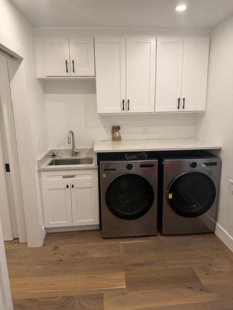 Custom laundry room with shaker cabinets and quartz counters