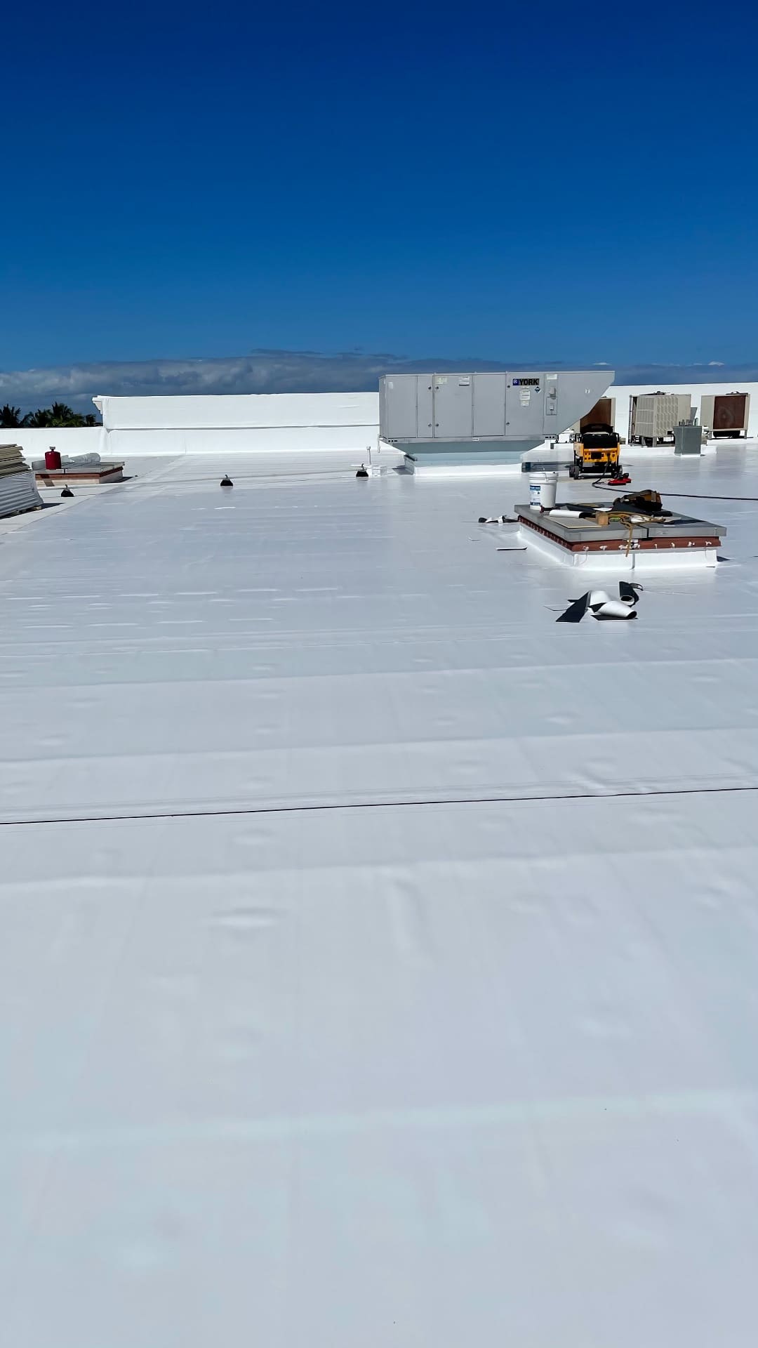 Completed white TPO commercial roof with rooftop HVAC equipment