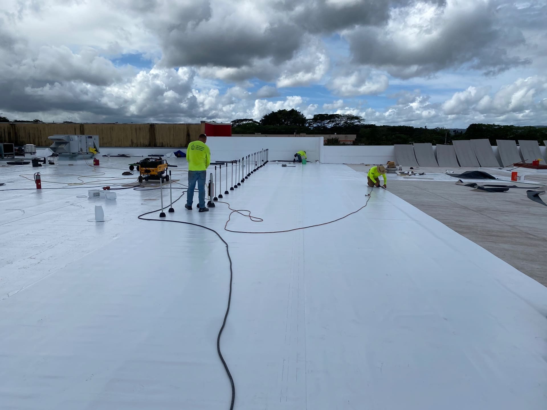 Titan Builder TPO roofing crew heat-welding membrane seams on a commercial flat roof