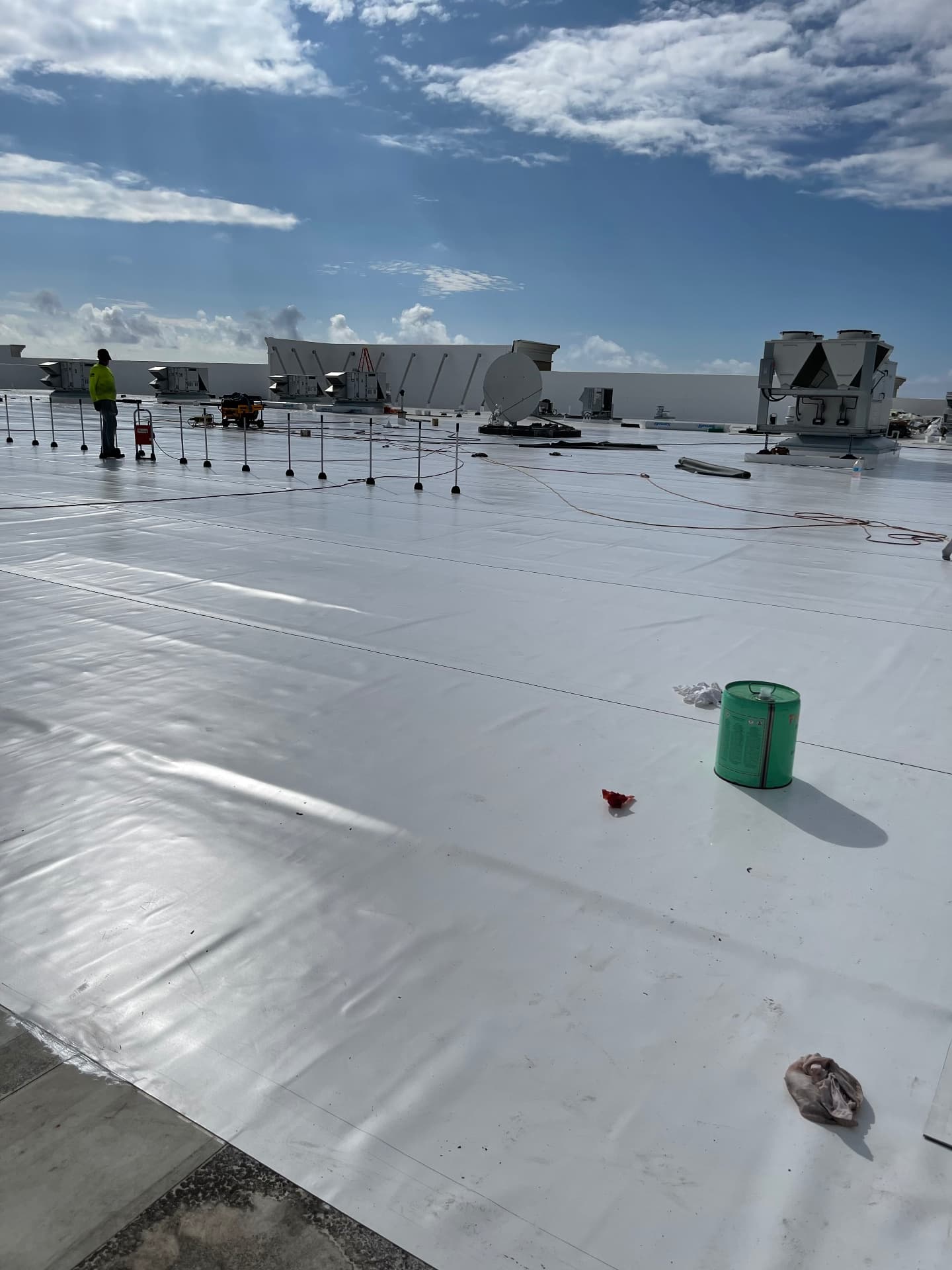 Wide finished white TPO commercial roof with rooftop equipment and open sky